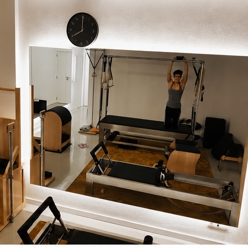 Reformers e Cadillac refletidos no espelho da sala do Centro Pilates Coimbra
